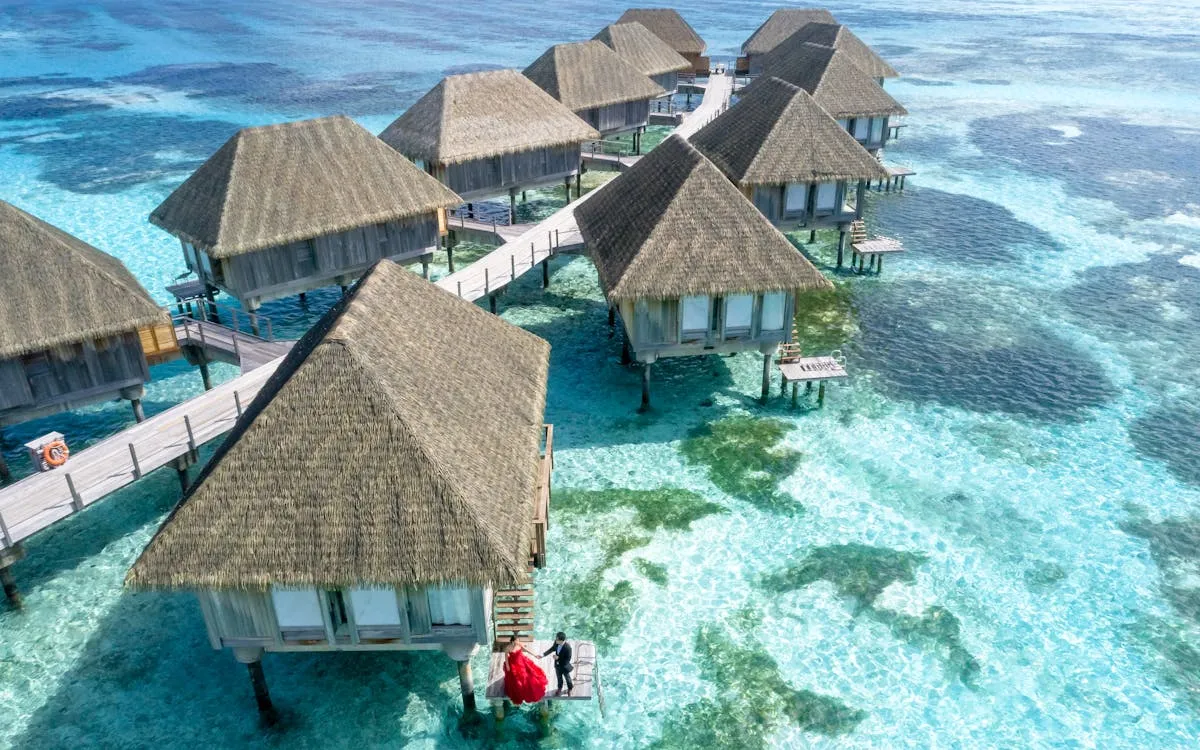 Aerial view of overwater villas on a turquoise lagoon in the Maldives